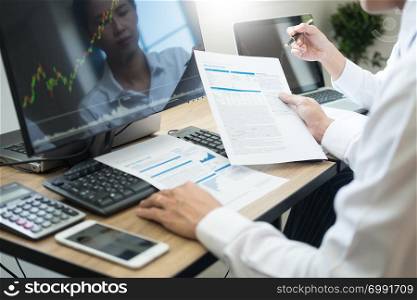 Business team trading Finance Stock Exchange analysis graph on multiple computer screens in modern trading office, financial and investment concept.