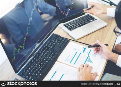 Business team trading Finance Stock Exchange analysis graph on multiple computer screens in modern trading office, financial and investment concept.