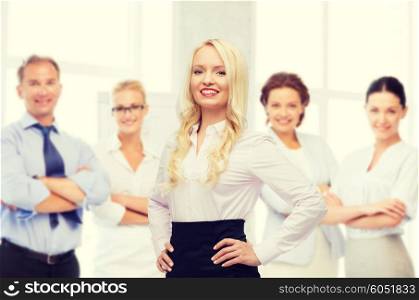 business, team work and people concept - smiling businesswoman, student or secretary over group of colleagues over office background