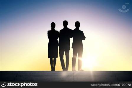 business, teamwork and people concept - business people silhouettes on stairs over sun light background