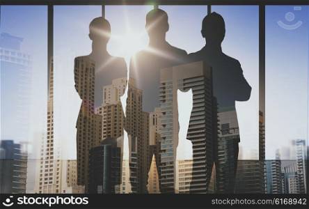 business, teamwork and people concept - business people silhouettes over double exposure office and city background