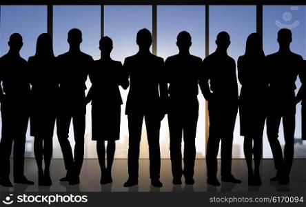 business, teamwork and people concept - business people silhouettes over office background
