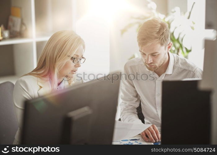 business, teamwork and people concept - creative team discussing papers at office table. business team discussing papers at office table. business team discussing papers at office table