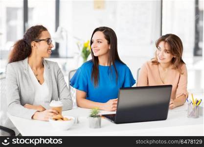 business, teamwork and people concept - female team or businesswomen with laptop computer working at office. businesswomen with laptop working at office. businesswomen with laptop working at office