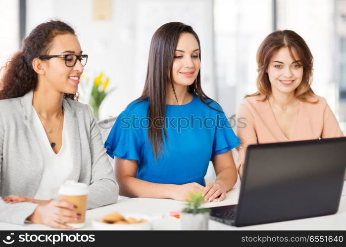 business, teamwork and people concept - female team or businesswomen with laptop computer working at office. businesswomen with laptop working at office. businesswomen with laptop working at office