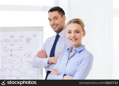 business, teamwork and people concept - smiling businessman and businesswoman in office