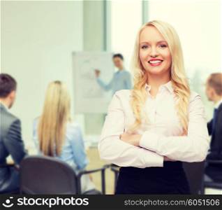business, teamwork and people concept - smiling businesswoman, student or secretary over office and group of colleagues background
