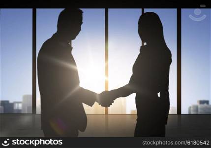 business, teamwork, partnership, cooperation and people concept - business people shaking hands over office background