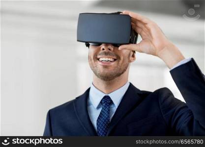 business, technology and augmented reality concept - smiling businessman with vr headset at office. businessman with virtual reality headset at office