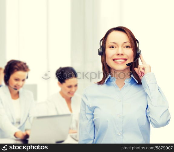 business, technology and call center concept - friendly female helpline operator with headphones at office