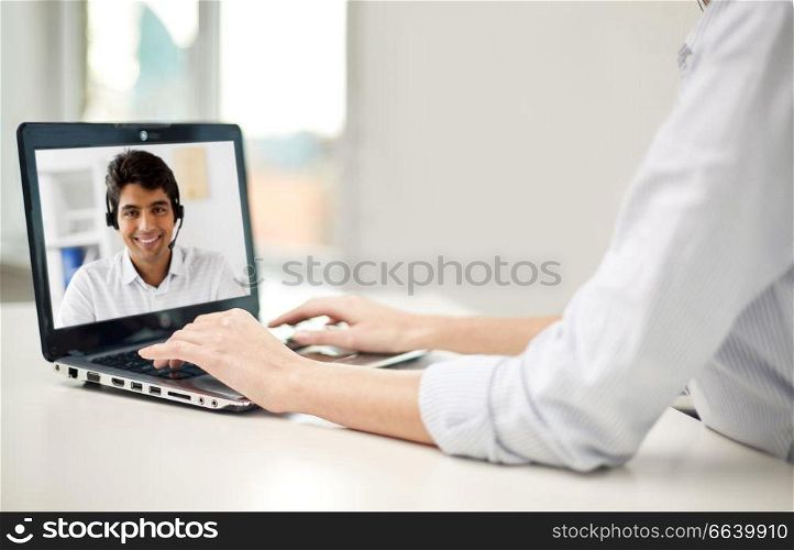 business, technology and communication concept - close up of businesswoman with laptop computer having video call with partner or customer service operator at office. businesswoman having video call on laptop