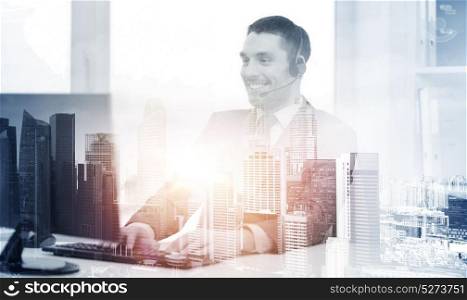 business, technology and communication concept - happy smiling male helpline operator or businessman with headset and computer at call center office over city background and double exposure effect. helpline operator with headset and computer