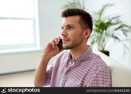 business, technology and communication concept - smiling young man calling on smartphone at office. smiling young man calling on smartphone at office