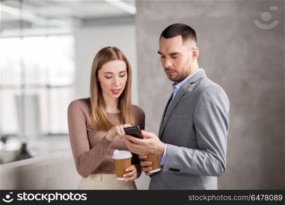 business, technology and corporate concept - businesswoman and businessman with smartphone drinking coffee at office. businesswoman and businessman with smartphone. businesswoman and businessman with smartphone