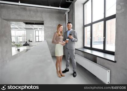 business, technology and corporate concept - happy smiling businesswoman and businessman with smartphone drinking coffee at office. businesswoman and businessman with smartphone. businesswoman and businessman with smartphone