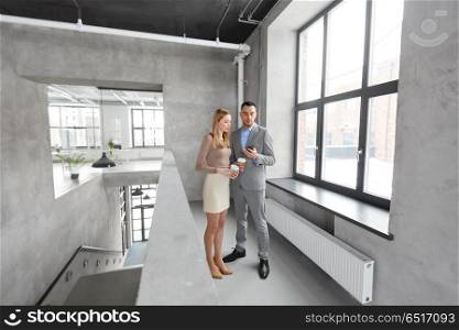 business, technology and corporate concept - happy smiling businesswoman and businessman with smartphone drinking coffee at office. businesswoman and businessman with smartphone. businesswoman and businessman with smartphone