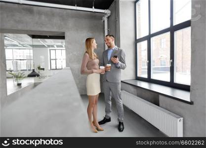 business, technology and corporate concept - happy smiling businesswoman and businessman with smartphone drinking coffee at office. businesswoman and businessman with smartphone