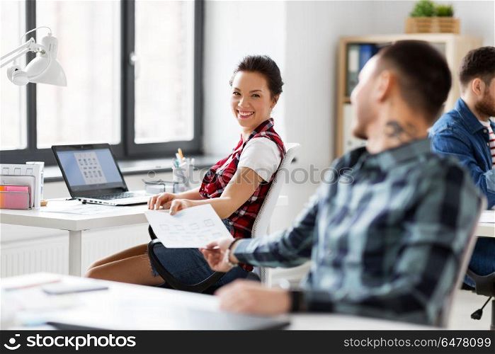 business, technology and creative people concept - designers with user interface mockup at office. creative office workers with user interface mockup. creative office workers with user interface mockup