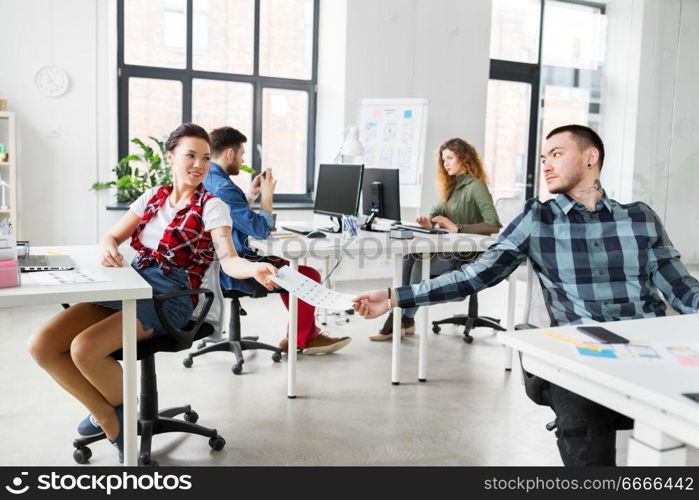 business, technology and creative people concept - designers with user interface mockup at office. creative office workers with user interface mockup. creative office workers with user interface mockup