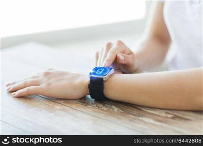 business, technology and cryptocurrency concept - close up of female hand wearing smart watch with bitcoin on screen. close up of hands with bitcoin on smart watch