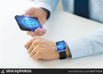 business, technology and cryptocurrency concept - close up of male hand holding smartphone and wearing smart watch with bitcoin on screen. close up of bitcoin on transparent smartphone. close up of bitcoin on transparent smartphone