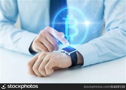 business, technology and cryptocurrency concept - close up of male hand wearing smart watch with bitcoin on screen. close up of hands with bitcoin on smart watch