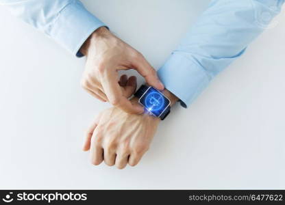 business, technology and cryptocurrency concept - close up of male hand wearing smart watch with bitcoin on screen. close up of hands with bitcoin on smart watch. close up of hands with bitcoin on smart watch