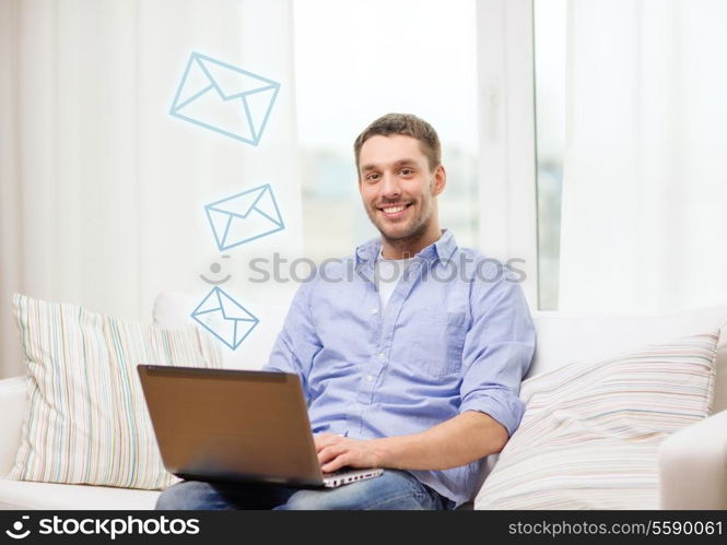 business, technology and e-learning concept - smiling man working with laptop at home