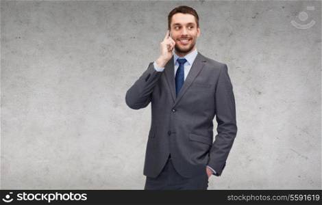 business, technology and education concept - friendly young smiling businessman with smartphone