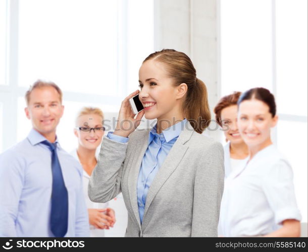 business, technology and education concept - friendly young smiling businesswoman with smartphone