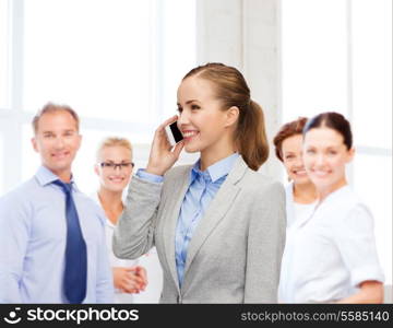 business, technology and education concept - friendly young smiling businesswoman with smartphone