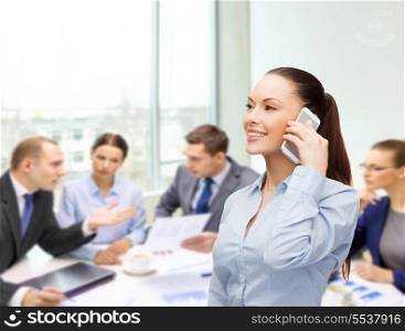 business, technology and education concept - friendly young smiling businesswoman with smartphone in office