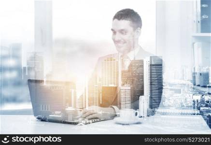 business, technology and internet concept - smiling businessman with laptop computer and coffee at office over city background and double exposure effect. businessman with laptop and coffee at office