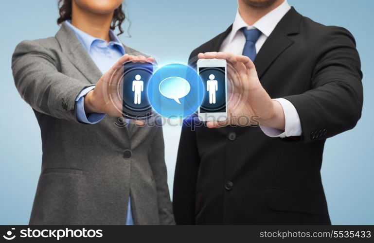 business, technology and internetconcept - businessman and businesswoman with social or business network on smartphone screens