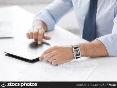 business, technology and office concept - businessman with tablet pc in office
