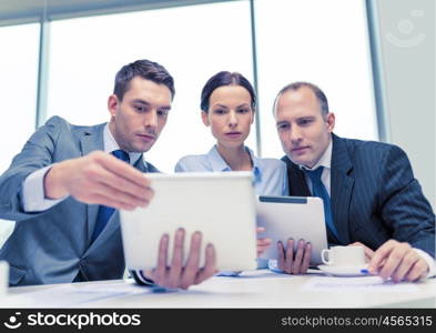 business, technology and office concept - serious business team with tablet pc computers, documents and coffee having discussion in office