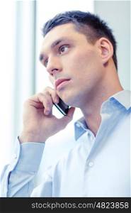 business, technology and office concept - serious businessman with smartphone