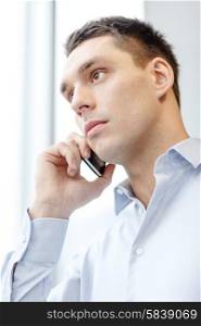 business, technology and office concept - serious businessman with smartphone