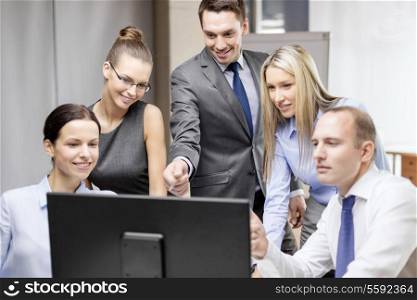 business, technology and office concept - smiling business team with computer monitor having discussion in office