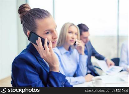 business, technology and office concept - smiling business team with smartphones making calls in office