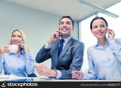 business, technology and office concept - smiling business team with smartphones making calls in office