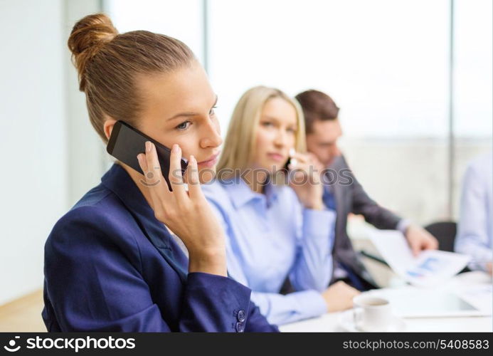 business, technology and office concept - smiling business team with smartphones making calls in office