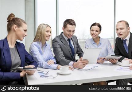 business, technology and office concept - smiling business team with tablet pc computer, documents and coffee having discussion in office