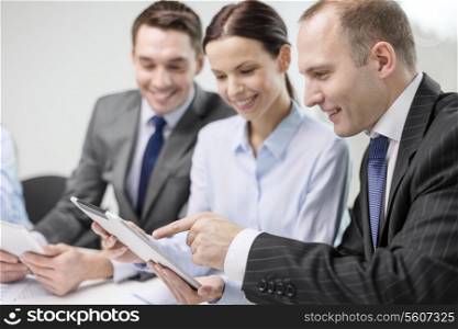 business, technology and office concept - smiling business team with tablet pc computer, documents and coffee having discussion in office