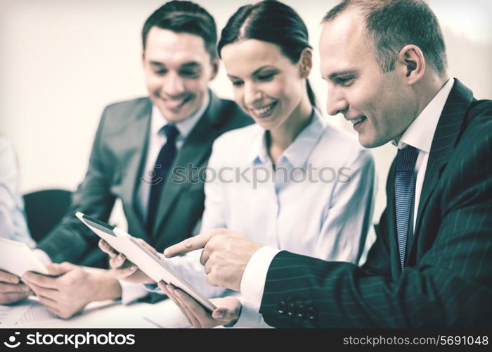 business, technology and office concept - smiling business team with tablet pc computer, documents and coffee having discussion in office