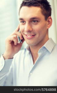 business, technology and office concept - smiling businessman with smartphone in office