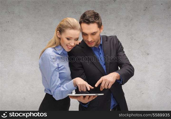 business, technology and office concept - smiling businesswoman and businessman looking at tablet pc computer