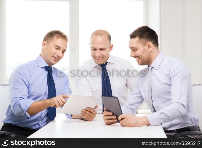 business, technology and office concept - three smiling businessmen with tablet pc computers in office