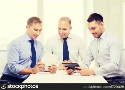business, technology and office concept - three smiling businessmen with tablet pc computers in office