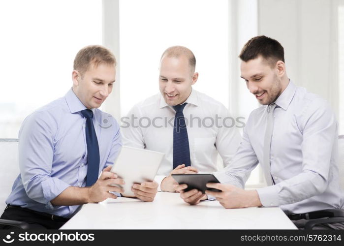 business, technology and office concept - three smiling businessmen with tablet pc computers in office